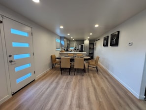 A modern kitchen with a central island, wooden flooring, and a dining area with chairs. - Cozy 2-bedroom house in Shoreline perfect for relaxing stays (Shoreline)