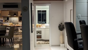 A modern kitchen with a dining area, a mirror, and a peacock feather decoration.