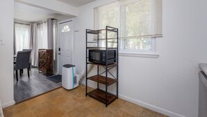 A compact living space with a kitchenette, a dining area, and a window with blinds. - 3/1 Home in Southfield, Near Hospitals & Parks (Southfield)