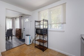 A compact living space with a kitchenette, a dining area, and a window with blinds. - 3/1 Home in Southfield, Near Hospitals & Parks (Southfield)