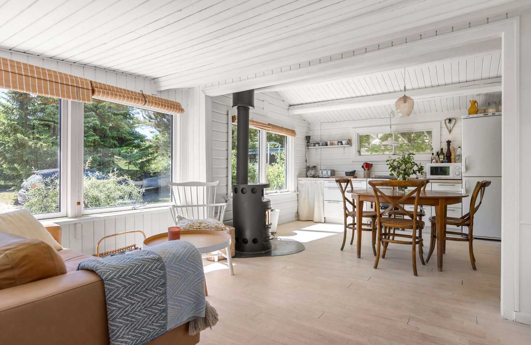 A modern interior with a dining area, kitchen, and a cozy seating area with a fireplace.