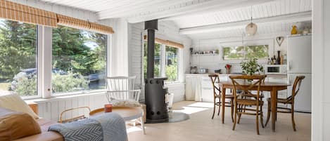A modern interior with a dining area, kitchen, and a cozy seating area with a fireplace.