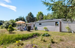 A mobile home with a patio area, a small deck, and a garden. - Idyllic holiday home with large garden (Fårevejle)