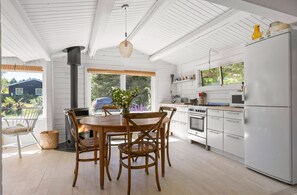 A kitchen with white cabinetry, a stove, and a refrigerator.