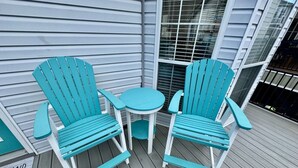 A wooden deck with two turquoise Adirondack chairs and a small round table. - Ocean Views, Ocean Breeze and the Sound of Waves (Myrtle Beach)