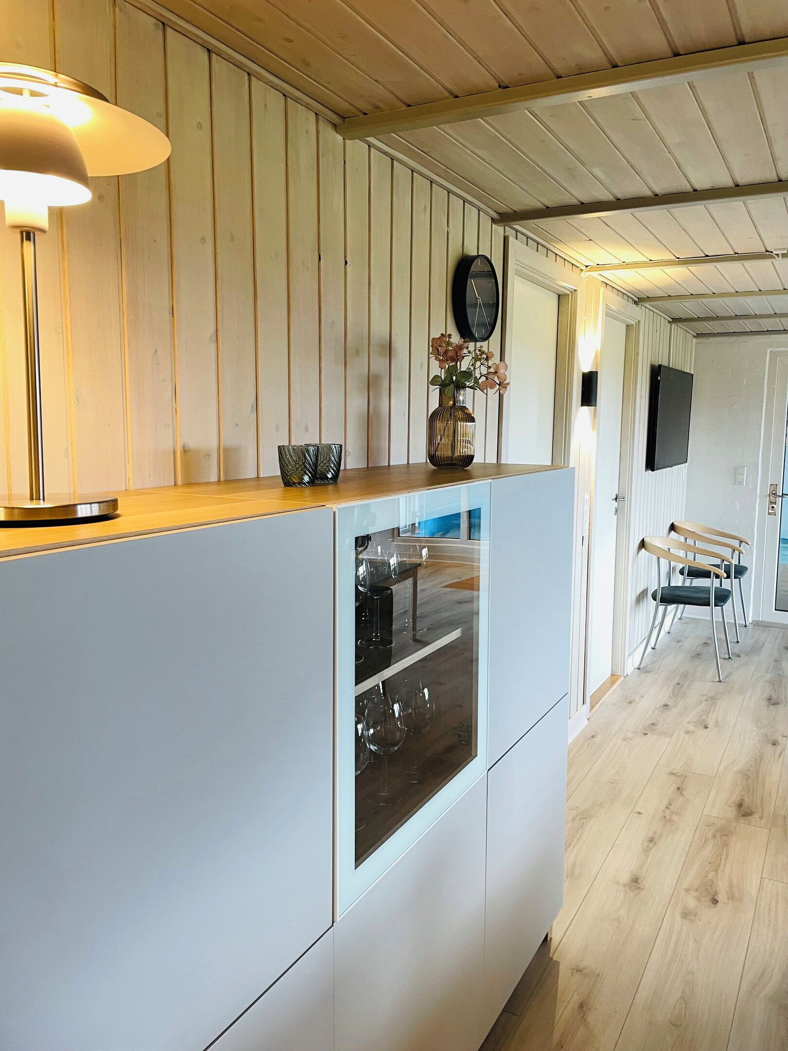 Une cuisine moderne dotée d’un plan de travail en bois, d’un four encastré et d’une horloge murale.