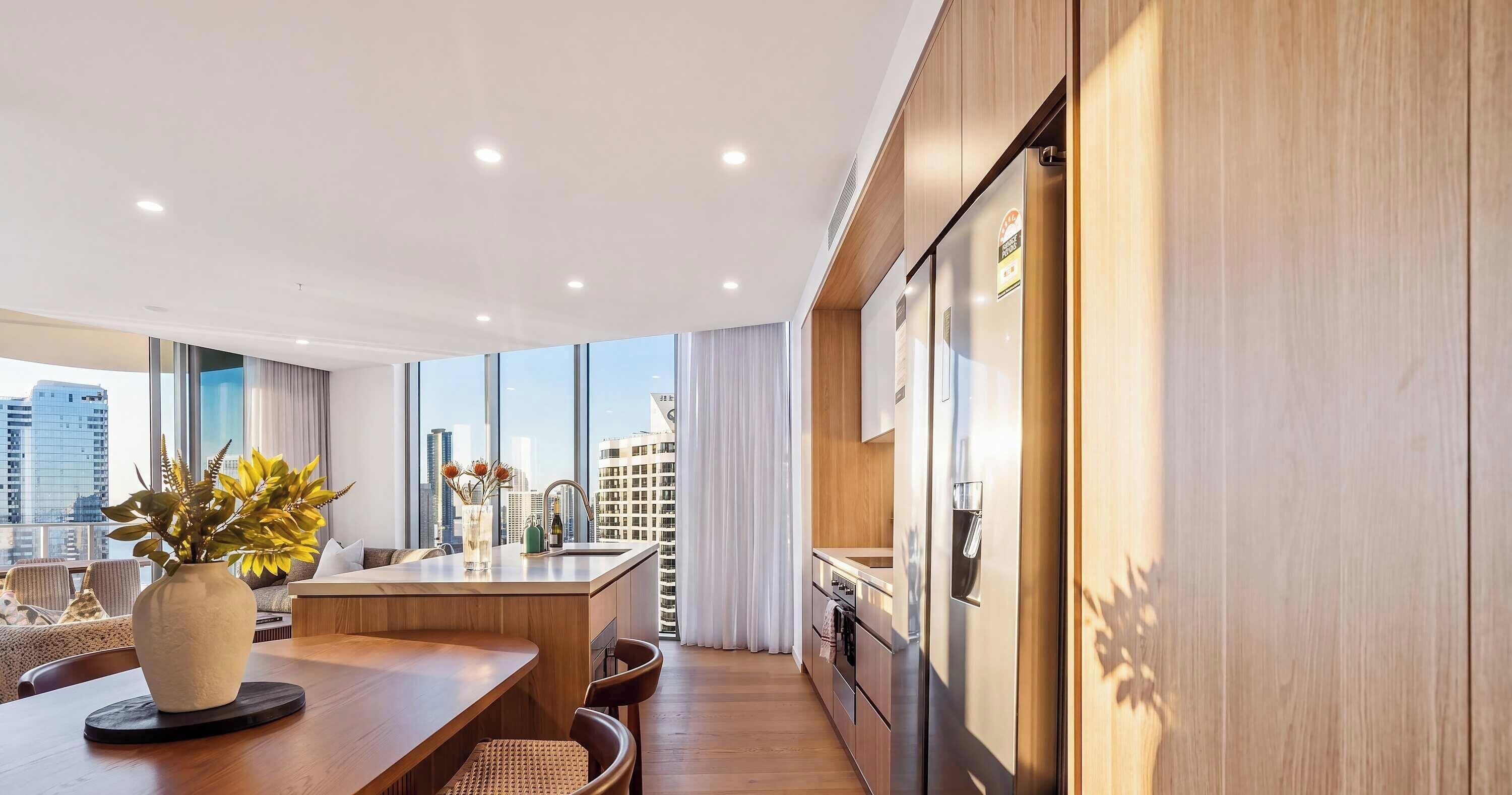 A modern kitchen with a built-in oven and a large window overlooking a cityscape.