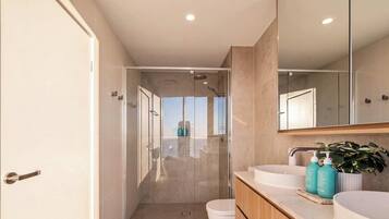 A modern bathroom with a shower, toilet, and sink area.