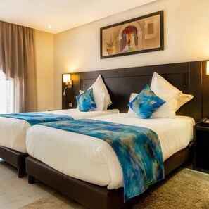 A hotel room with two beds, a dark headboard, and a painting on the wall. - LE PALM MENRA HOTEL MARRAKEH (Marrakech)