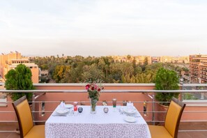 A table set for dining on a balcony with a city view. - LE PALM MENRA HOTEL MARRAKEH (Marrakech)