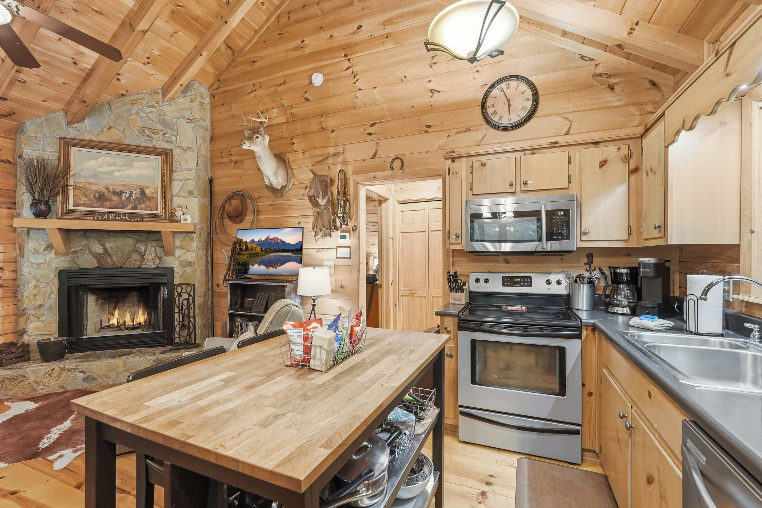 Eine rustikale Küche mit Kamin aus Stein, Holzschränken und einem Essbereich mit Tisch.