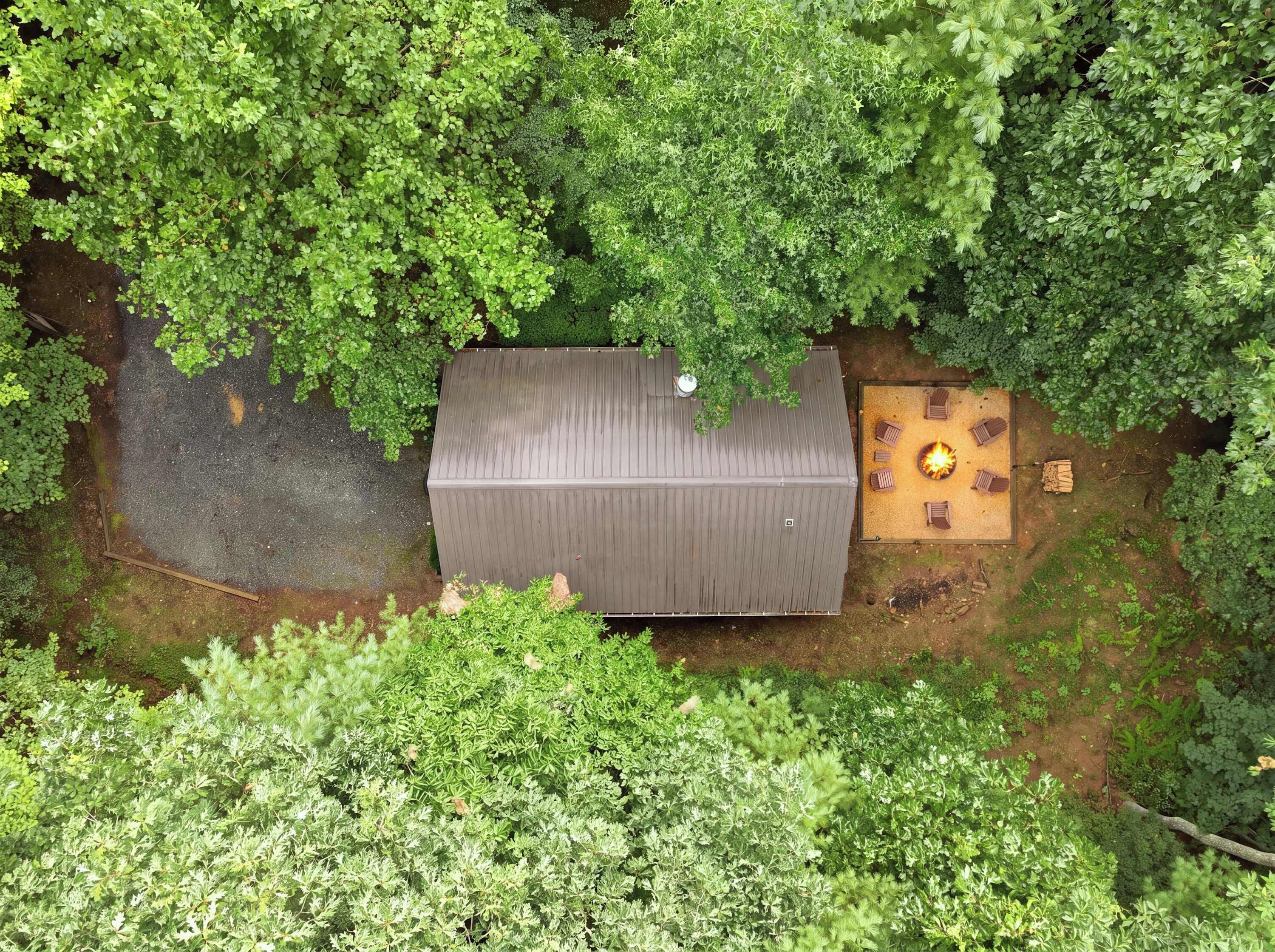 Un bâtiment rectangulaire doté d’un toit plat, entouré d’un feuillage verdoyant et dense.