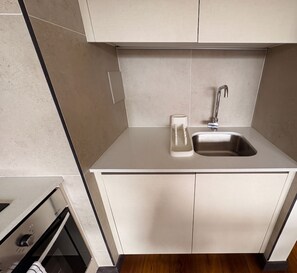 A modern kitchen with a built-in sink, a coffee maker, and a stove.