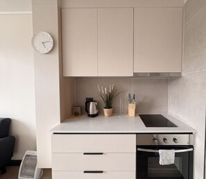 Appartement, 1 slaapkamer | Privékeuken | Een koelkast, een magnetron, een oven, kookgerei, borden en bestek