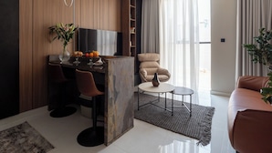 Een moderne woonkamer met een televisie, zitplaatsen, een salontafel en een plant.