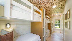 Une chambre avec des lits superposés, un dressing et une fenêtre donnant sur un beau paysage.