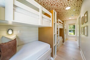 Ein Schlafzimmer mit Etagenbetten, einem begehbaren Kleiderschrank und einem Fenster mit Blick.
