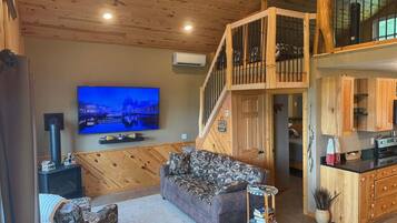 Una sala acogedora con sofá, televisión y chimenea.