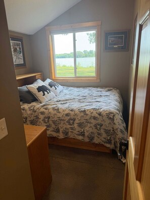 Ein Schlafzimmer mit Bett, Fenster und Tür.