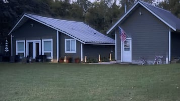 A two-story house with a front porch, a garage, and an American flag.