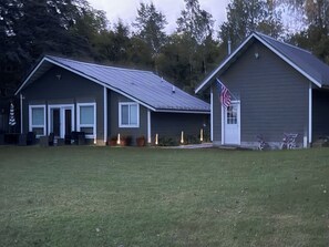Et toetagers hus med en veranda, garage og et amerikansk flag.