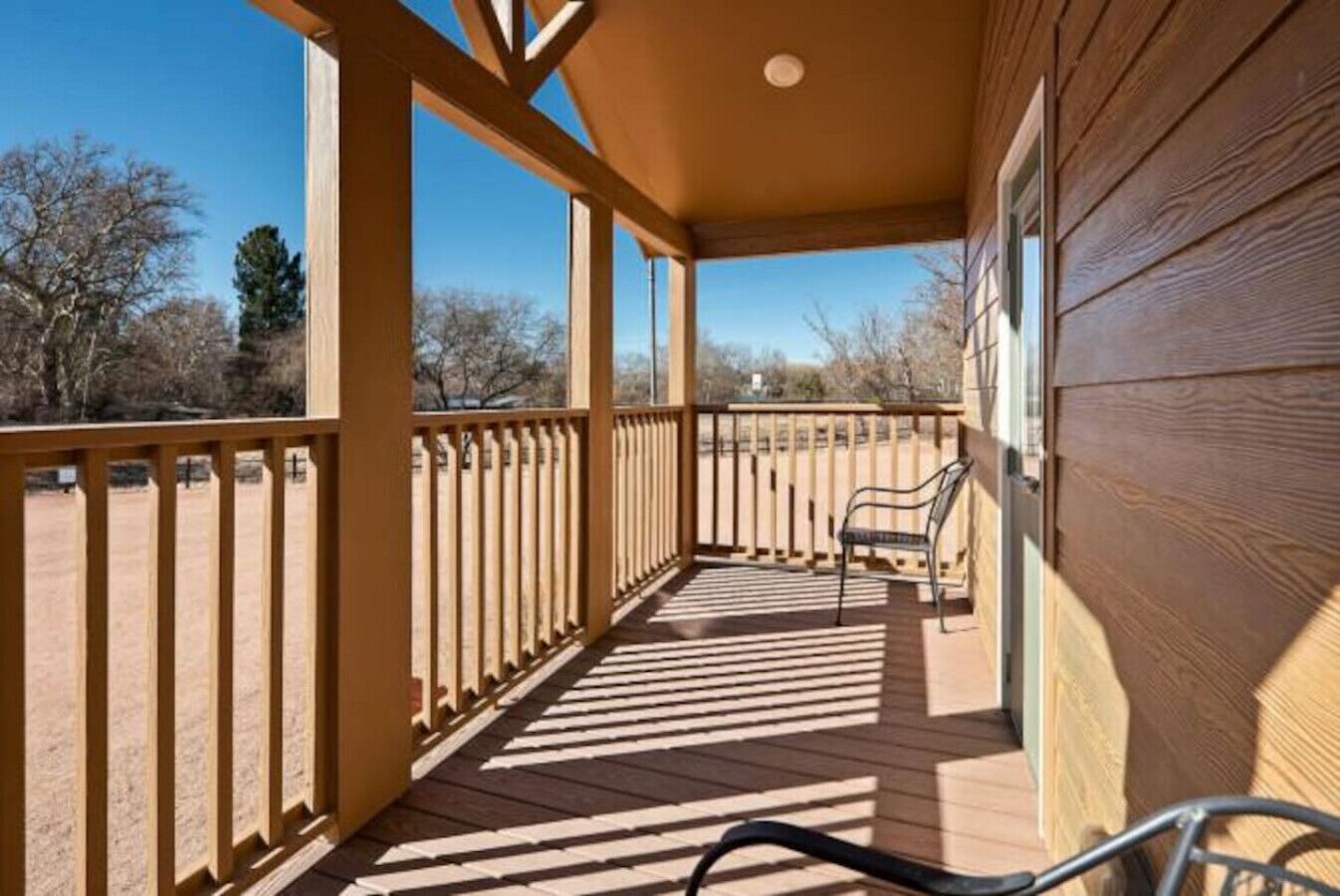 A wooden deck with a railing, a bench, and a bicycle.