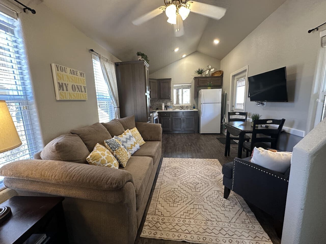 A living room with a sofa, a rug, and a television.