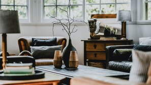 A cozy living room with a fireplace, a coffee table, and a bookshelf.