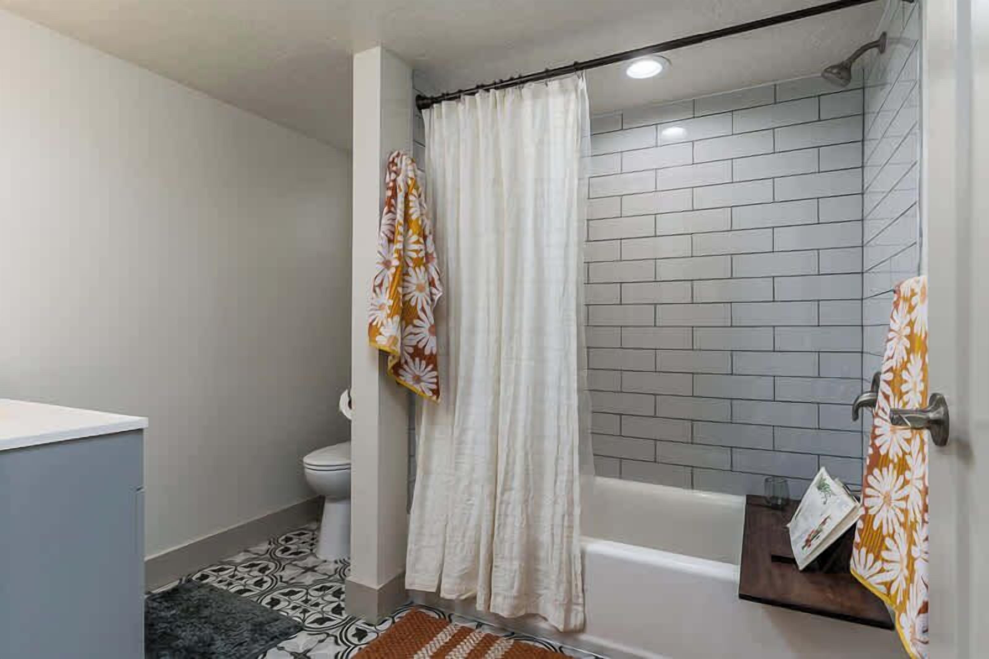 Un baño con ducha, inodoro y bañera.