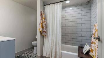 Un baño con ducha, inodoro y bañera.