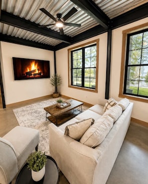 A living room with a fireplace, a sofa, a coffee table, and a television. - The Shipwreck Shack • Castle Rock Lake • Sleeps 18 (Mauston)