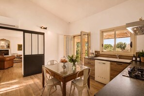 Eine moderne Küche mit Essbereich, eingebautem Backofen und Blick ins Freie.