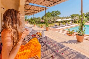 A patio with a pool, lounge chairs, and potted plants. - Ô · Ô1 L'Aube Collection — 5-bedroom villa with private pool, Lecci, Southern Corsica (San-Gavino-di-Carbini)
