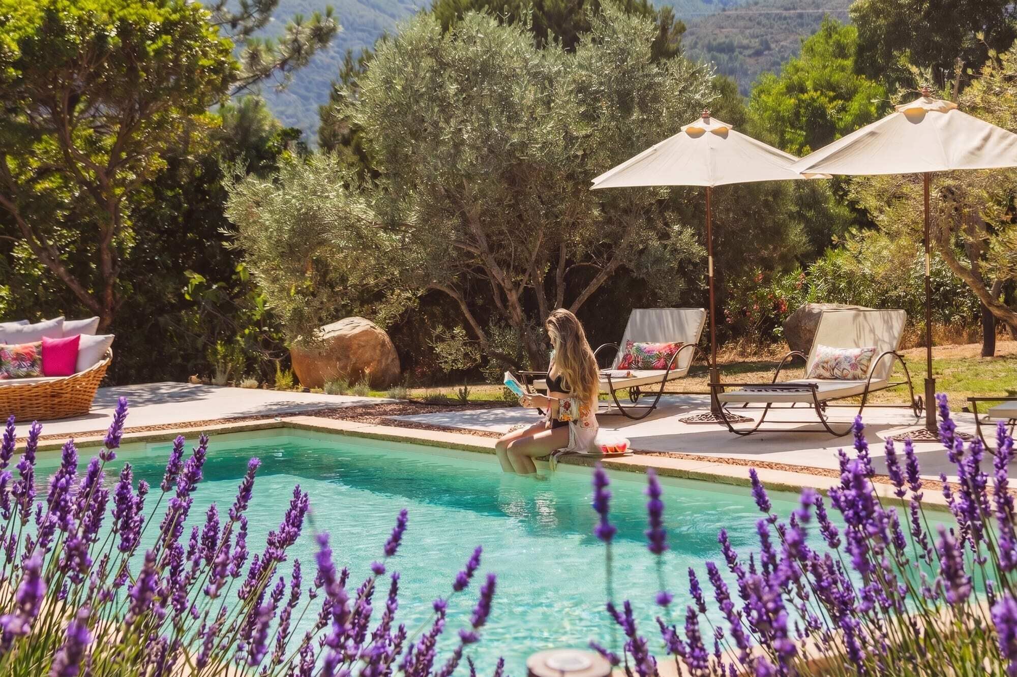 A pool area with a clear view of the surrounding landscape, including trees and a mountain in the background.