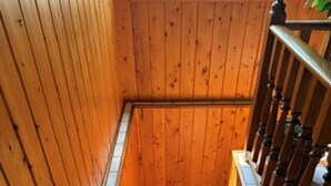 A wooden staircase with a carpeted landing and a handrail. - Cozy cabin on All Sports Lake with private beach! Close to ski resorts & trails (Atlanta)