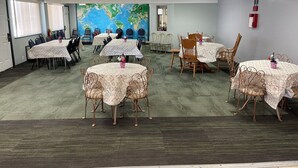 Una sala de conferencias con varias mesas y sillas, un mapa mundial en la pared y un extintor.