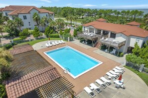 A swimming pool surrounded by lounge chairs and a covered patio area. - A Sandcastle! Beach Front, Hot Tub, Community Pool, Beach Gear Credit! (St. George Island)