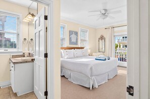 A hotel room with a bed, a bathroom, and a balcony. - A Sandcastle! Beach Front, Hot Tub, Community Pool, Beach Gear Credit! (St. George Island)