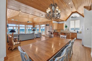 A spacious kitchen with wooden cabinets, a large island, and a view of the sea. - A Sandcastle! Beach Front, Hot Tub, Community Pool, Beach Gear Credit! (St. George Island)