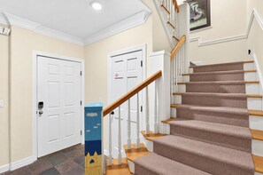 A staircase with carpeted steps and wooden handrails, leading to a landing with a door. - A Sandcastle! Beach Front, Hot Tub, Community Pool, Beach Gear Credit! (St. George Island)