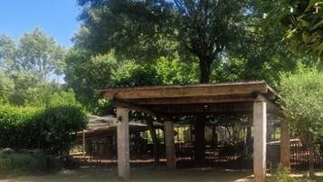 Un espace extérieur abrité, doté d’une pergola, d’une table et de chaises.