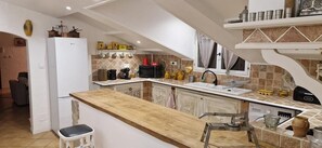 Une cuisine dotée d’un plan de travail en bois, d’un réfrigérateur blanc et de divers appareils de cuisine.