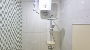 A bathroom with a shower, a toilet, and a water heater. - Little Home Mangga Besar (Jakarta)