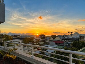 A sunset view over a residential area with buildings and a clear sky. - Teani Skyline | Downtown Papeete • Terrace • Moorea View • A/C • Parking (Papeete)