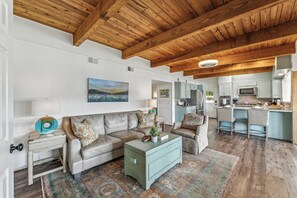 A spacious living room with a high ceiling, a sofa, a coffee table, and a patterned rug. - All about that Bass lake house on beautiful lay lake (Shelby)