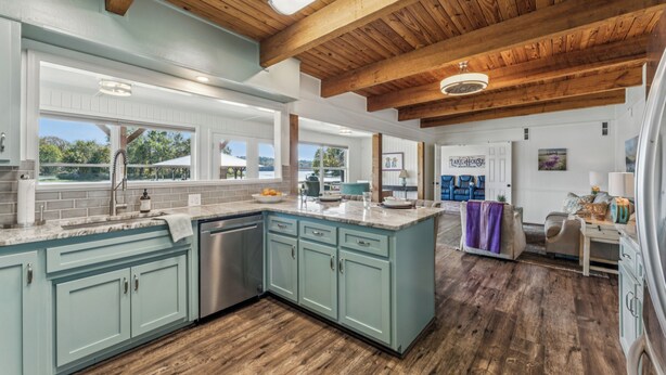 A spacious kitchen with light blue cabinets, a large island, and wooden beams on the ceiling. - All about that Bass lake house on beautiful lay lake (Shelby)