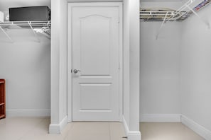 A white door with a simple design, a metal shelf above it, and a tiled floor. - The Club Brickell | 39th Floor Bay View (Miami)