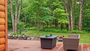 An outdoor deck with a fire pit, seating, and a view of a forest. - Winter Court by Avantstay Game Room Private Basketball Court Fire Pit Near Skiing & Raceway (Pocono Summit)