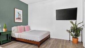 A bedroom with a bed, a green nightstand, a potted plant, and a wall-mounted TV. - The Encore by Avantstay Pool + Hot Tub + Outdoor Pool Table + Fire Pit Mins to the Polo Fields (Indio)
