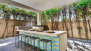 An outdoor bar area with a tiled backsplash, a grill, and bar stools. - The Encore by Avantstay Pool + Hot Tub + Outdoor Pool Table + Fire Pit Mins to the Polo Fields (Indio)